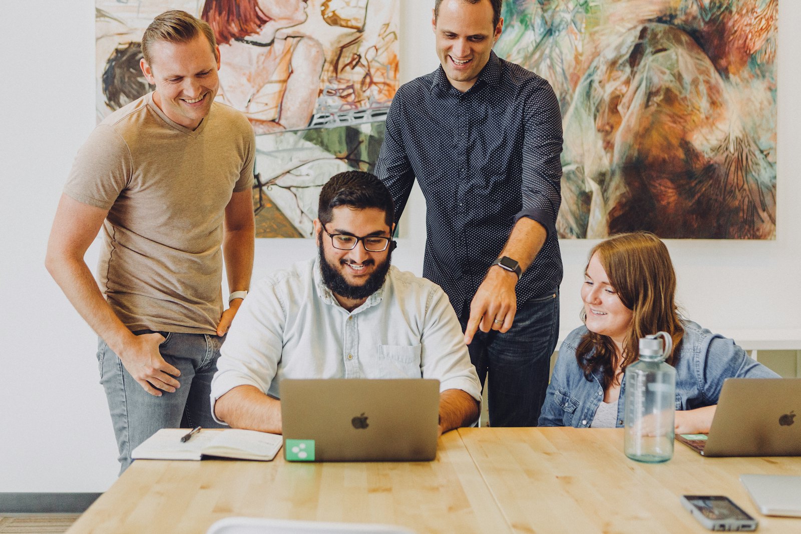 Team collaborating around a laptop